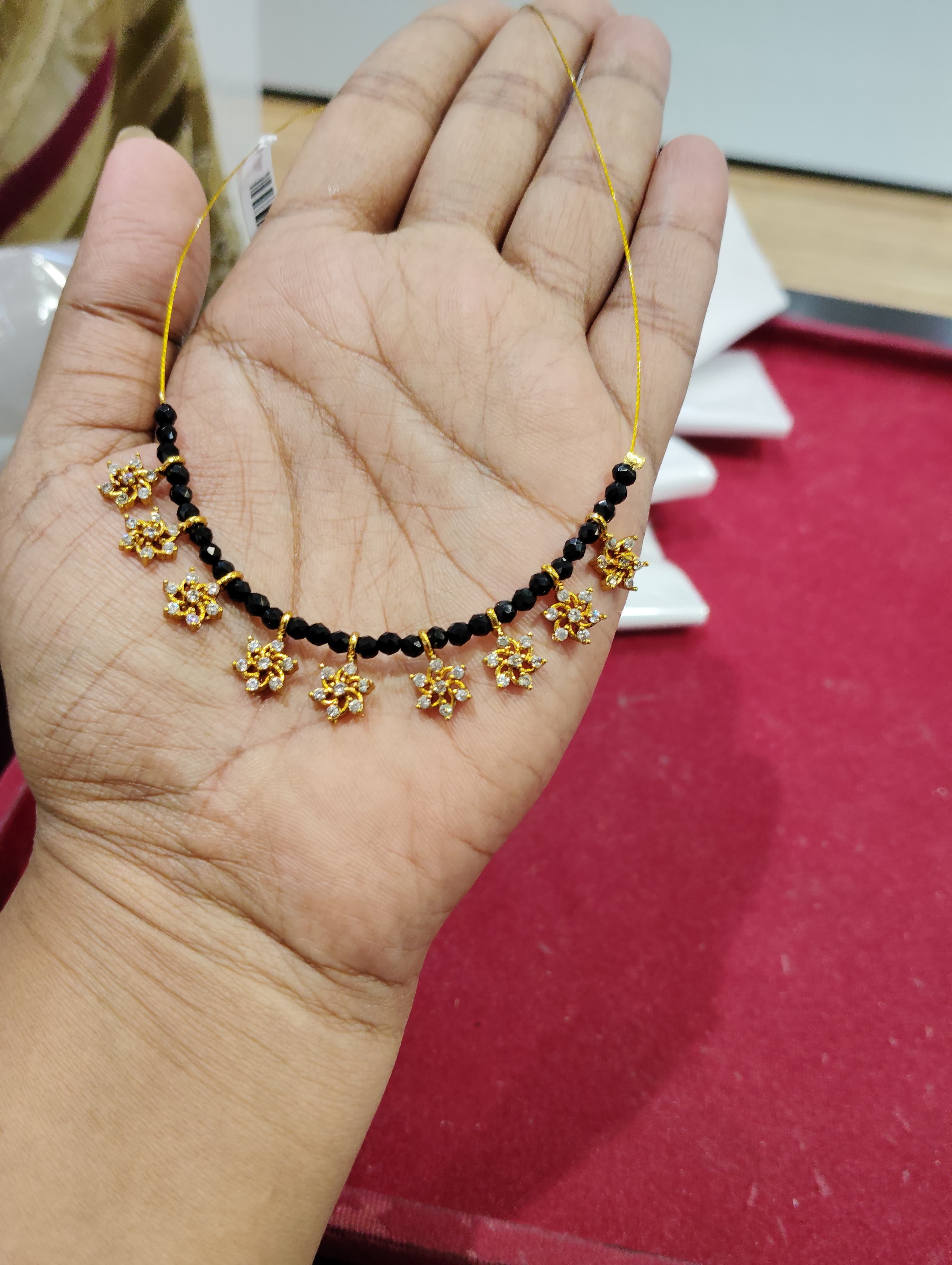 Mangalsutra with faceted black beads and small gold-tone floral charms