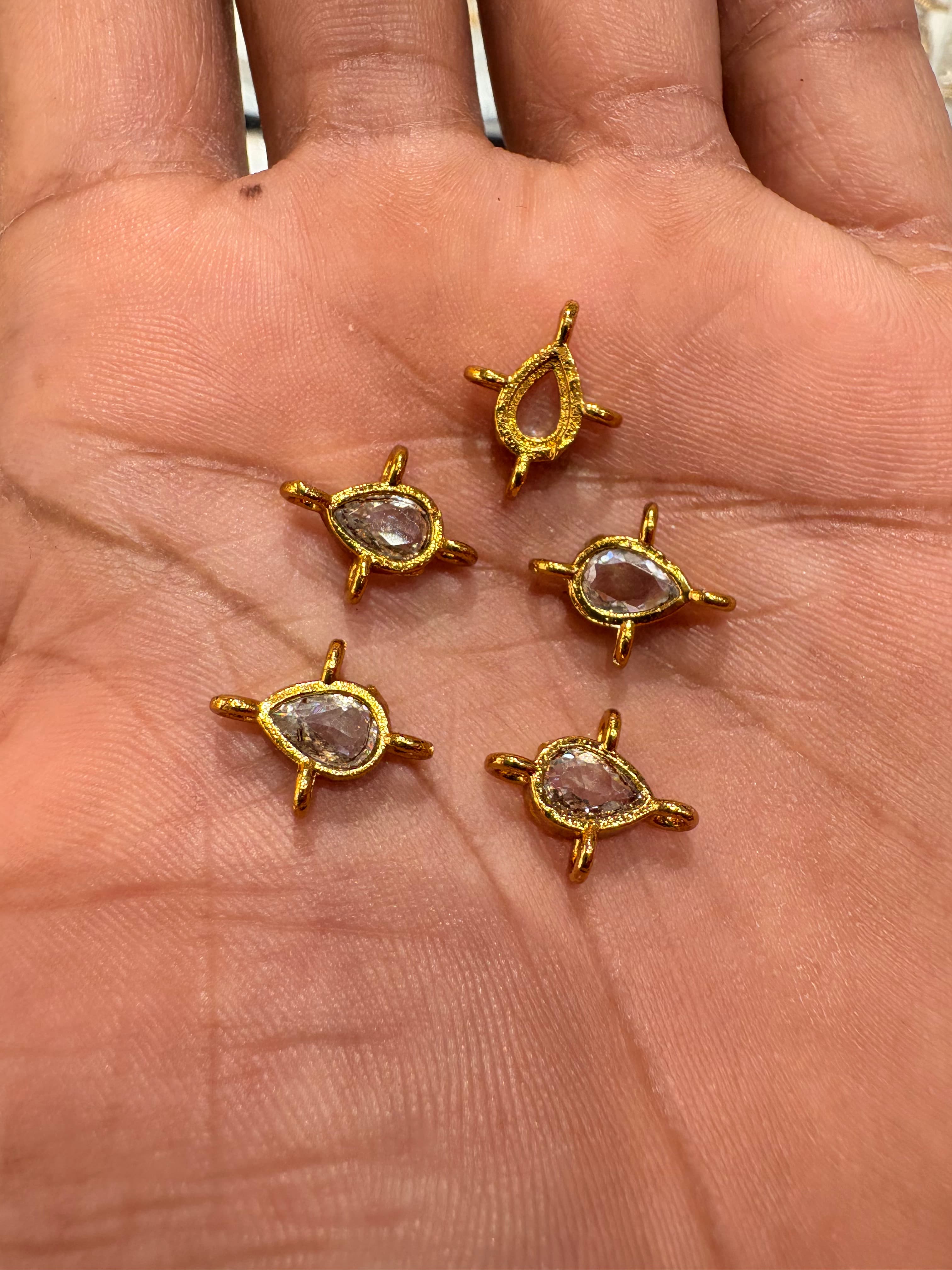 Small gold-coloured teardrop connectors with clear teardrop accents and four tiny loops