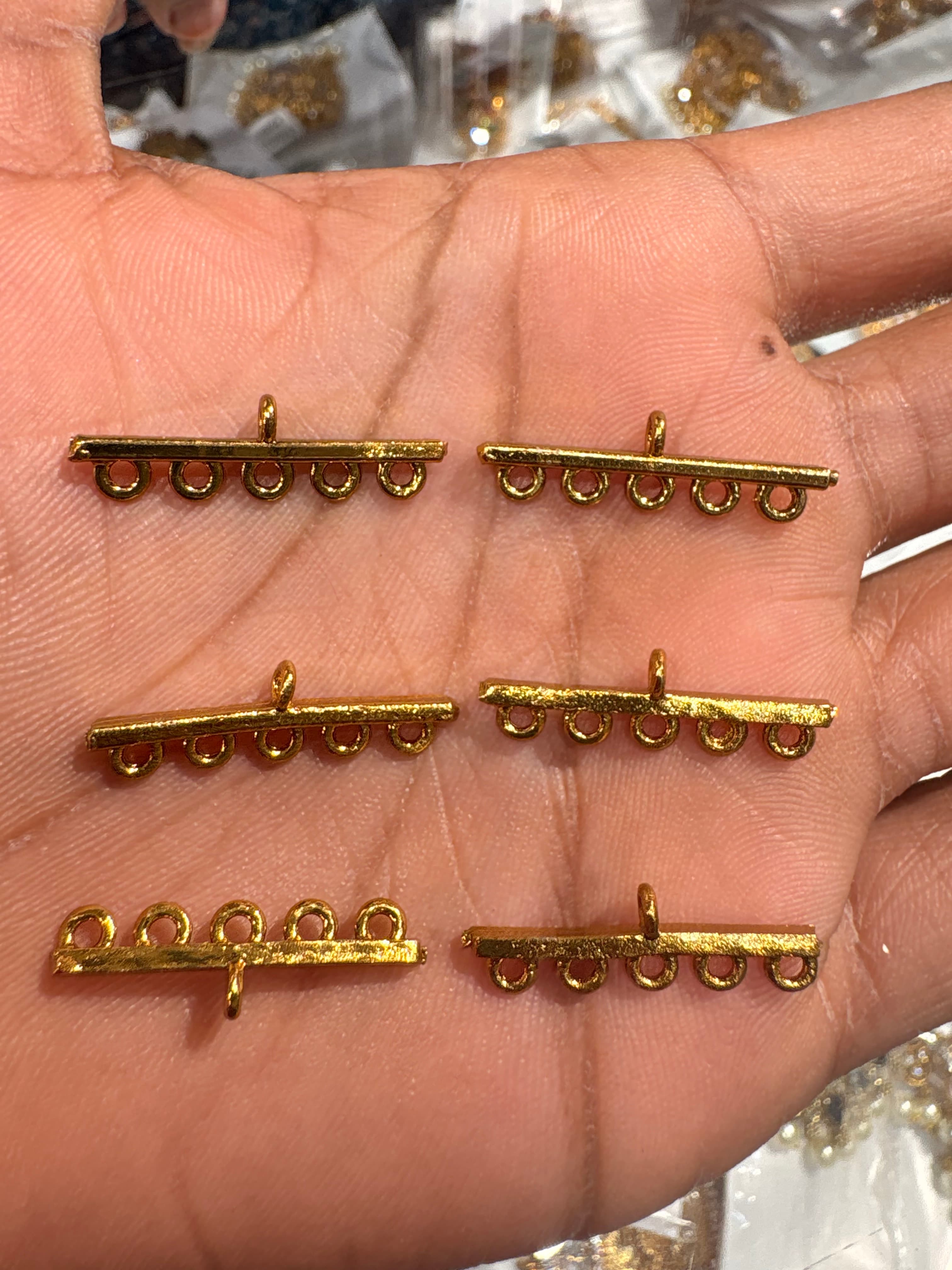 Gold-colour horizontal connector bar with four round lower loops and a top loop