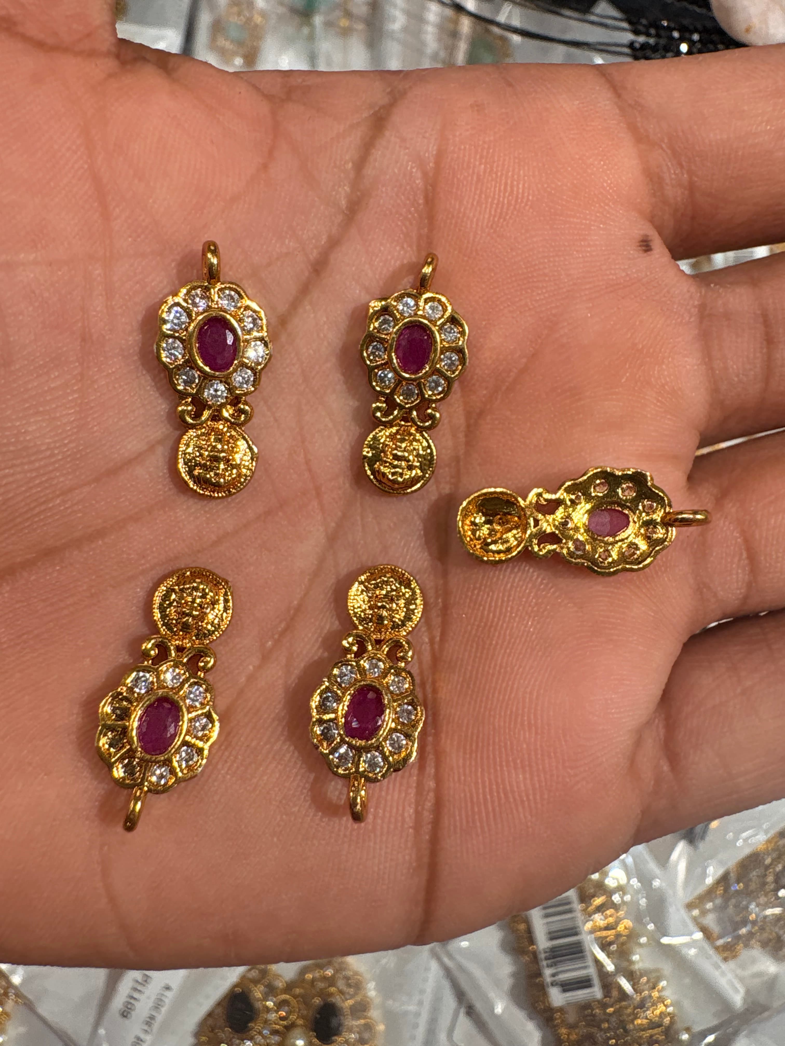 Gold-tone floral pendant with pink oval centre, clear accents and small coin drop