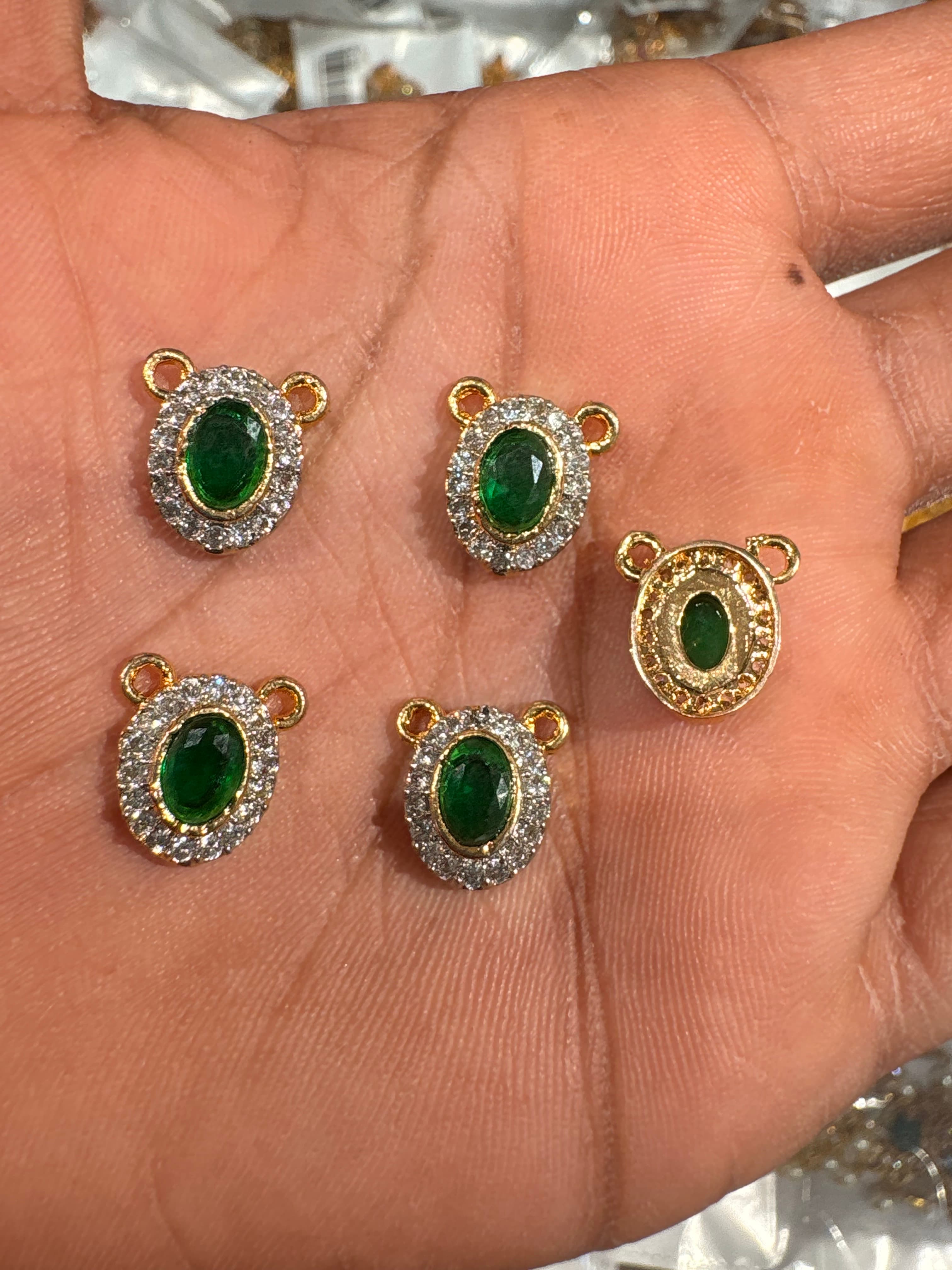 Small gold-tone oval connector with green centre and clear crystal halo and two top loops