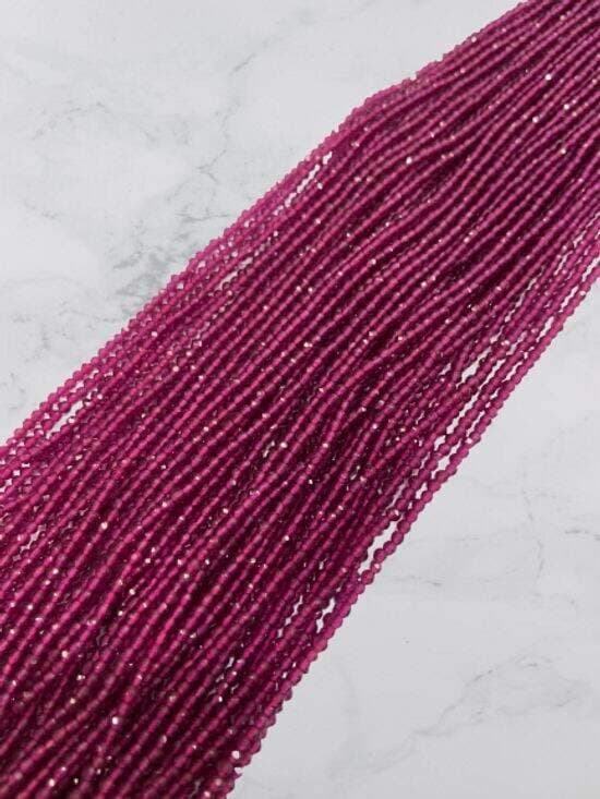 Multiple strands of small faceted round magenta beads with sparkling facets
