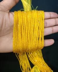 Multiple fine strands of small glossy yellow hydro beads bundled together