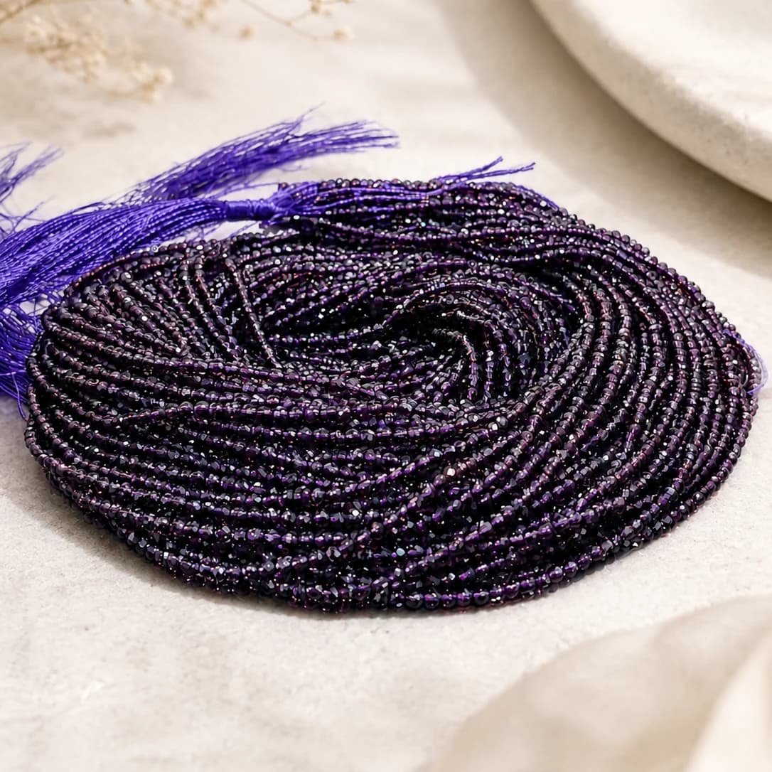 Coiled strand of small faceted purple hydro beads with purple threaded ends