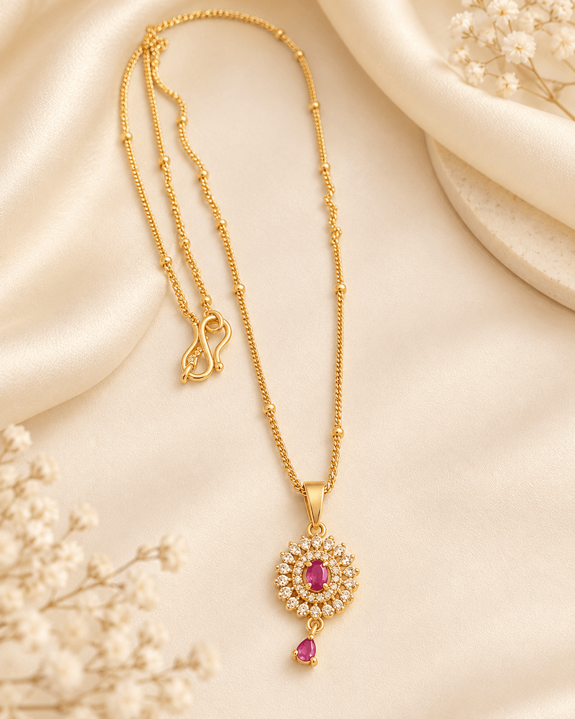 Yellow-metal-tone chain necklace with a round floral halo pendant and pink oval and pear drop accents