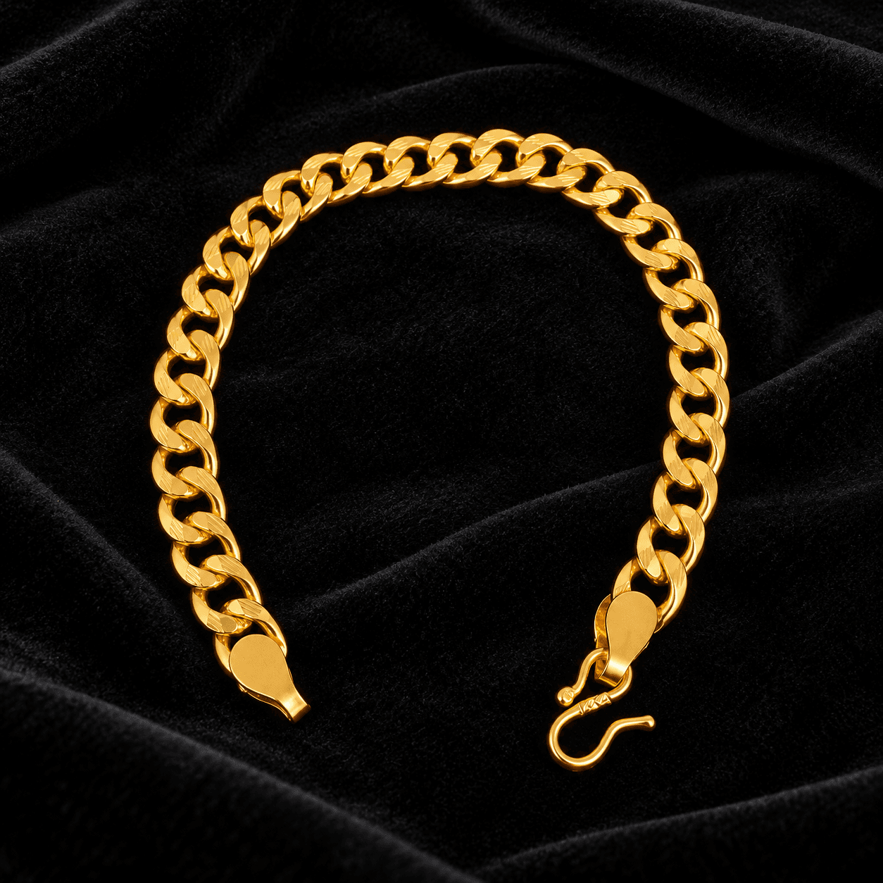 Gold-tone curb chain bracelet with a hook clasp on black fabric