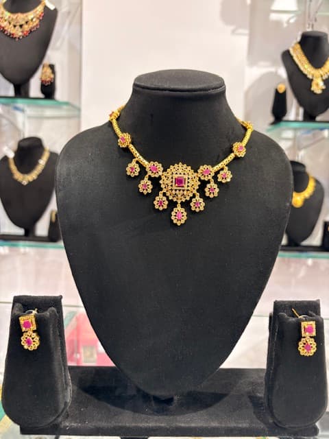 Necklace set on black bust with square pink centre and floral hanging drops plus matching earrings