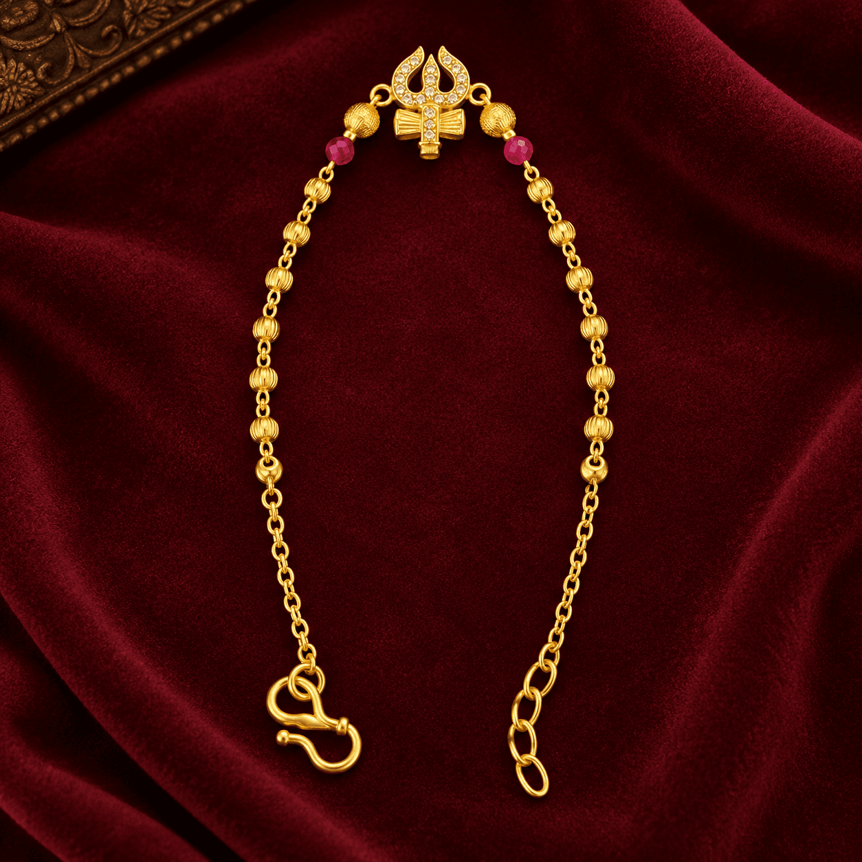 Gold-tone bracelet with ribbed beads, pink accents and a decorative top motif